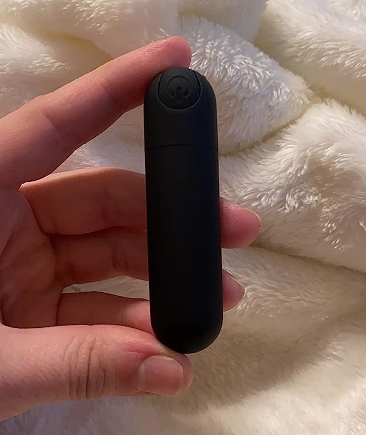 Reviewer holding small black bullet vibrator
