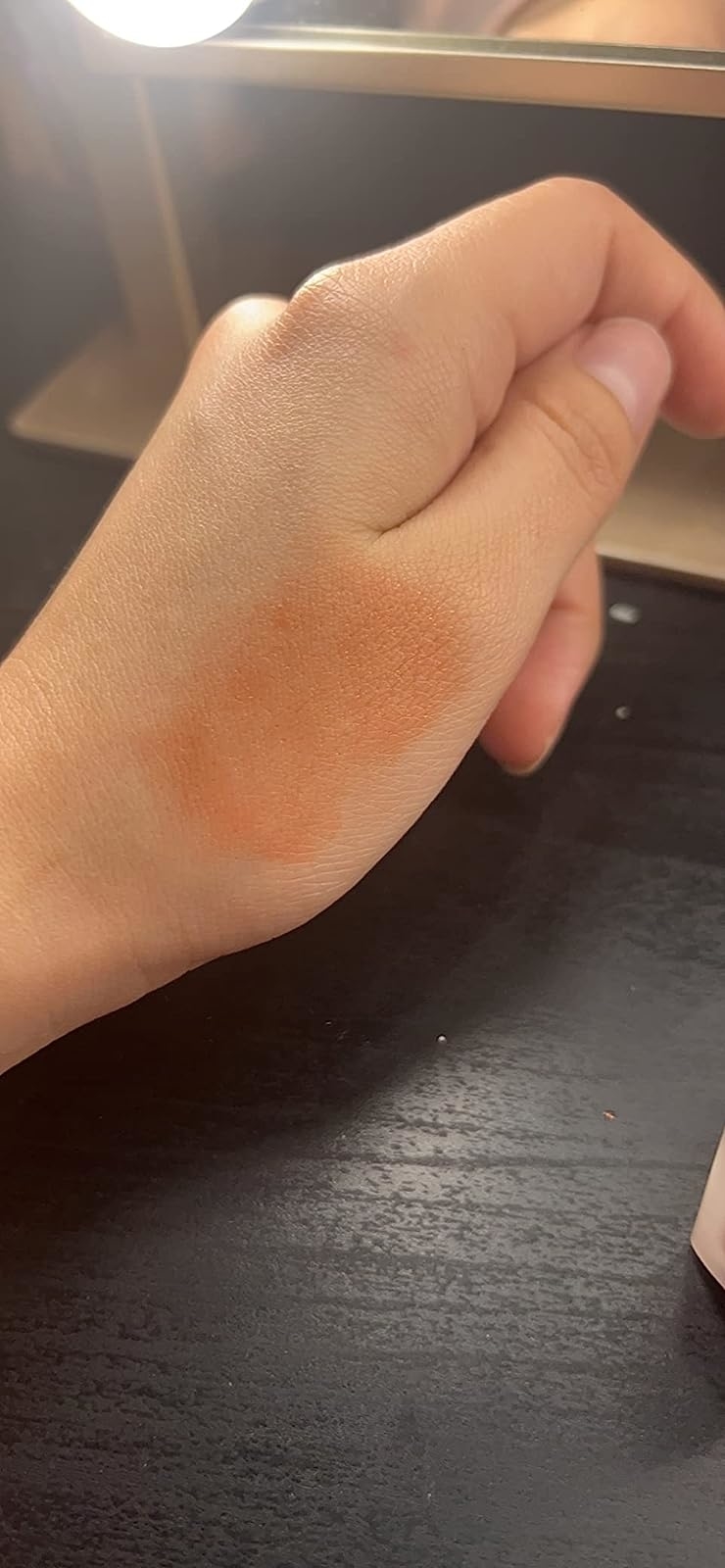 A reviewer showing a swatch of blush