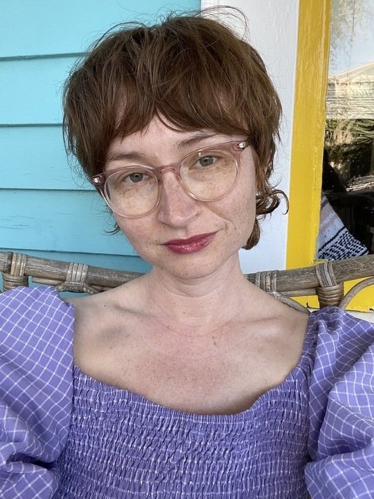 the author taking a selfie in a purple dress with smocked bodice