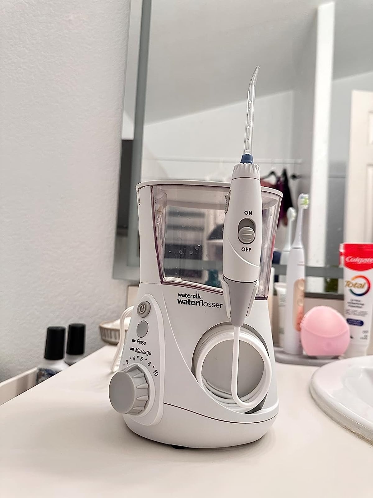 reviewer image of the white water flosser on a bathroom countertop