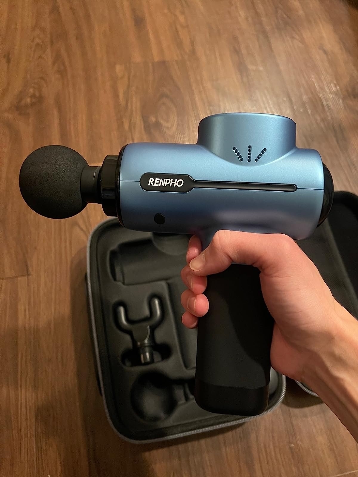 image of reviewer holding up the massage gun