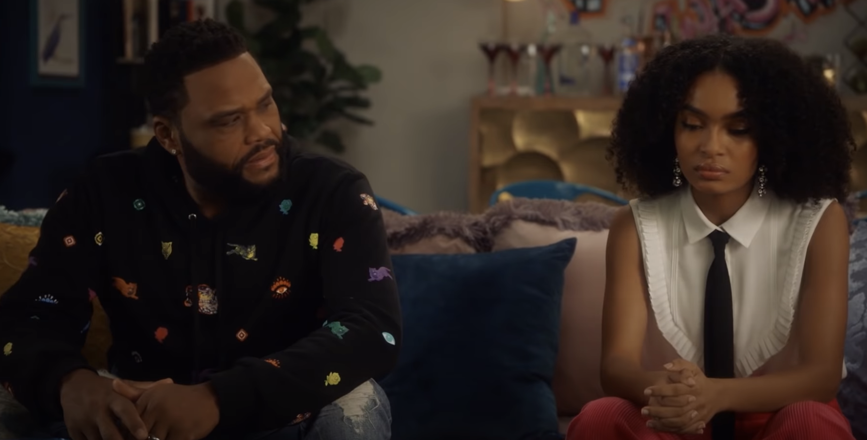 Dre from Black-ish sitting on a couch and looking at Zoey