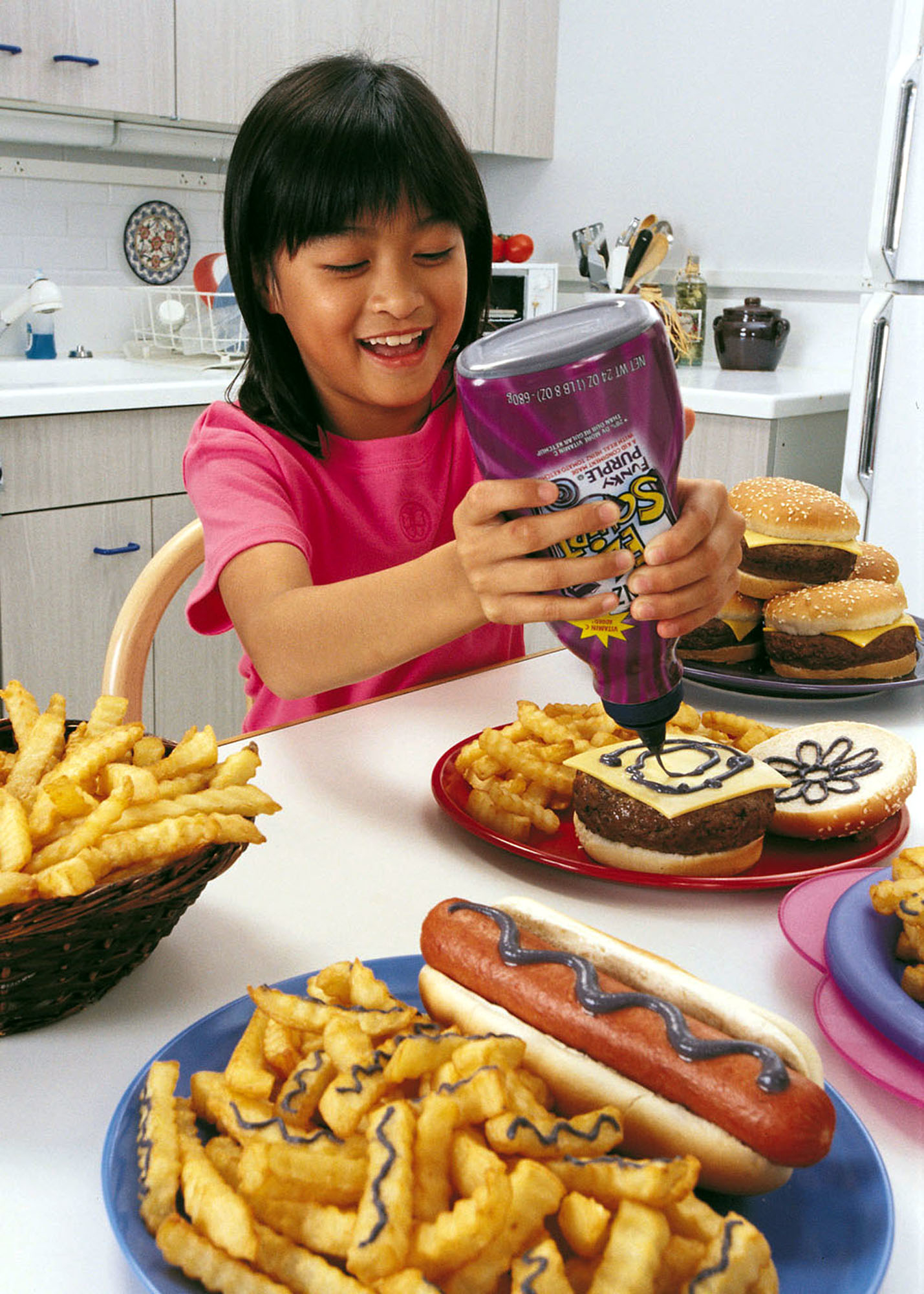 This undated photo shows a girl using Heinz&#x27;&#x27;s new &quot;Funky Purple&quot; ketchup bottle