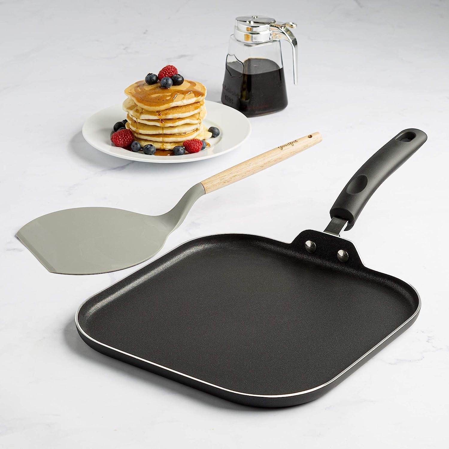flat nonstick griddle pan with a handle and a wide turner with a wood handle