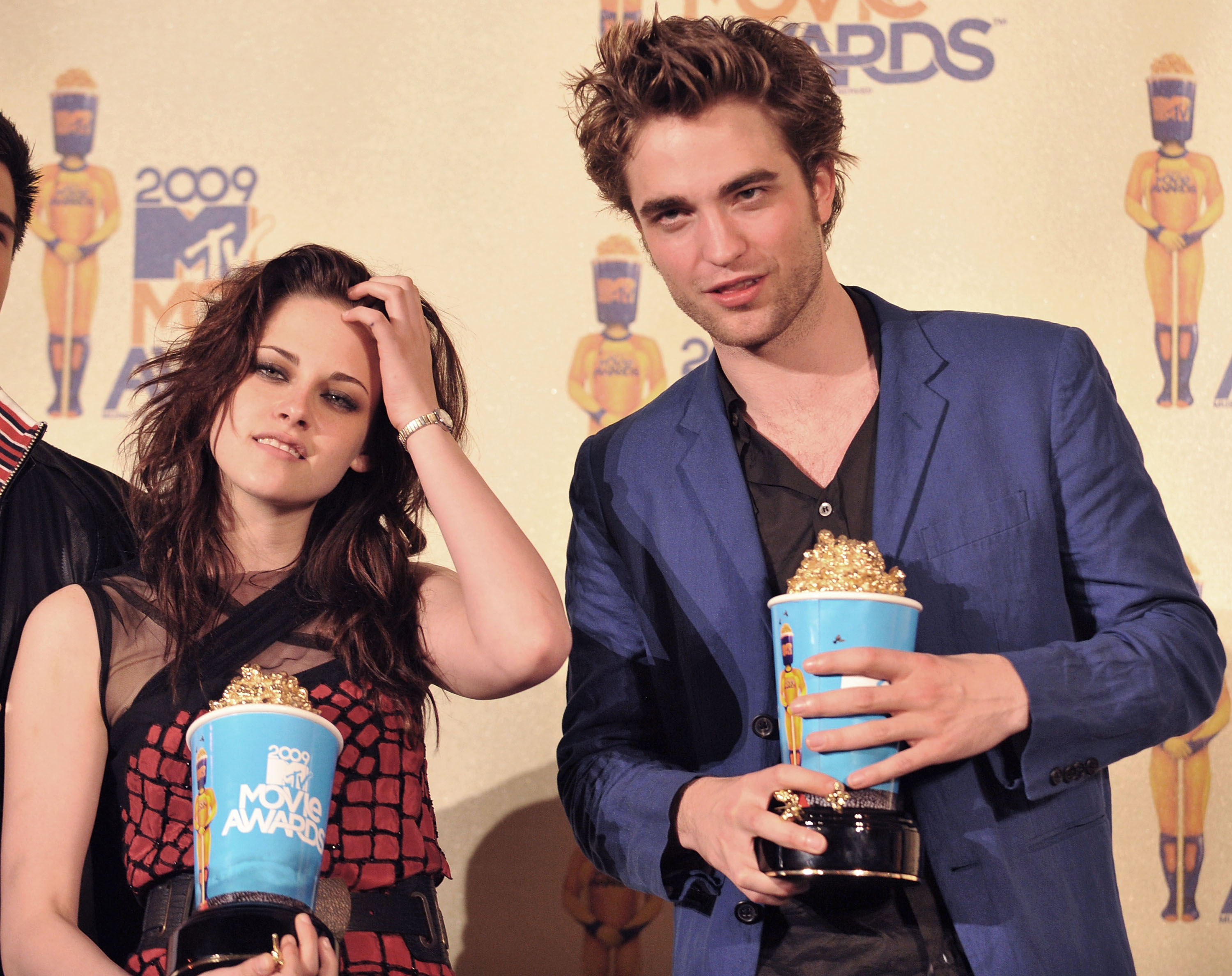 Kristen Stewart and Robert Pattinson posing with popcorn shaped awards