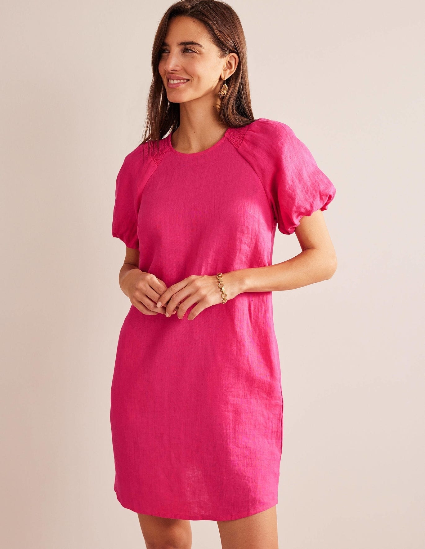 A model wearing a short pink dress.