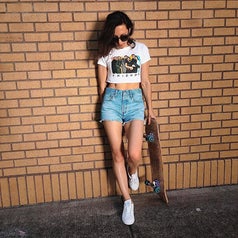 reviewer wearing the denim shorts and a cropped tee