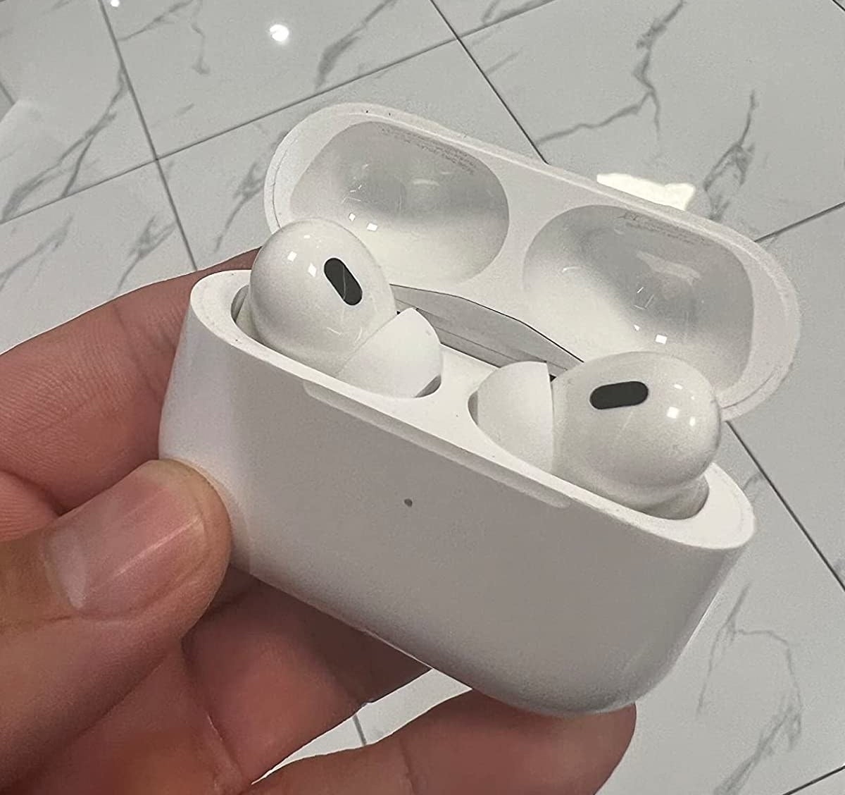 reviewer holding the open airpods case