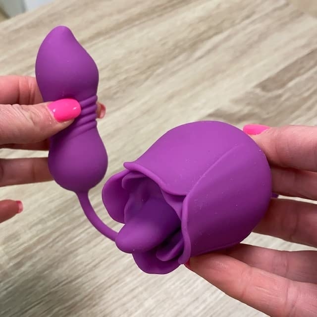 Reviewer holding purple dual-stimulator with rose-shaped clitoral arm