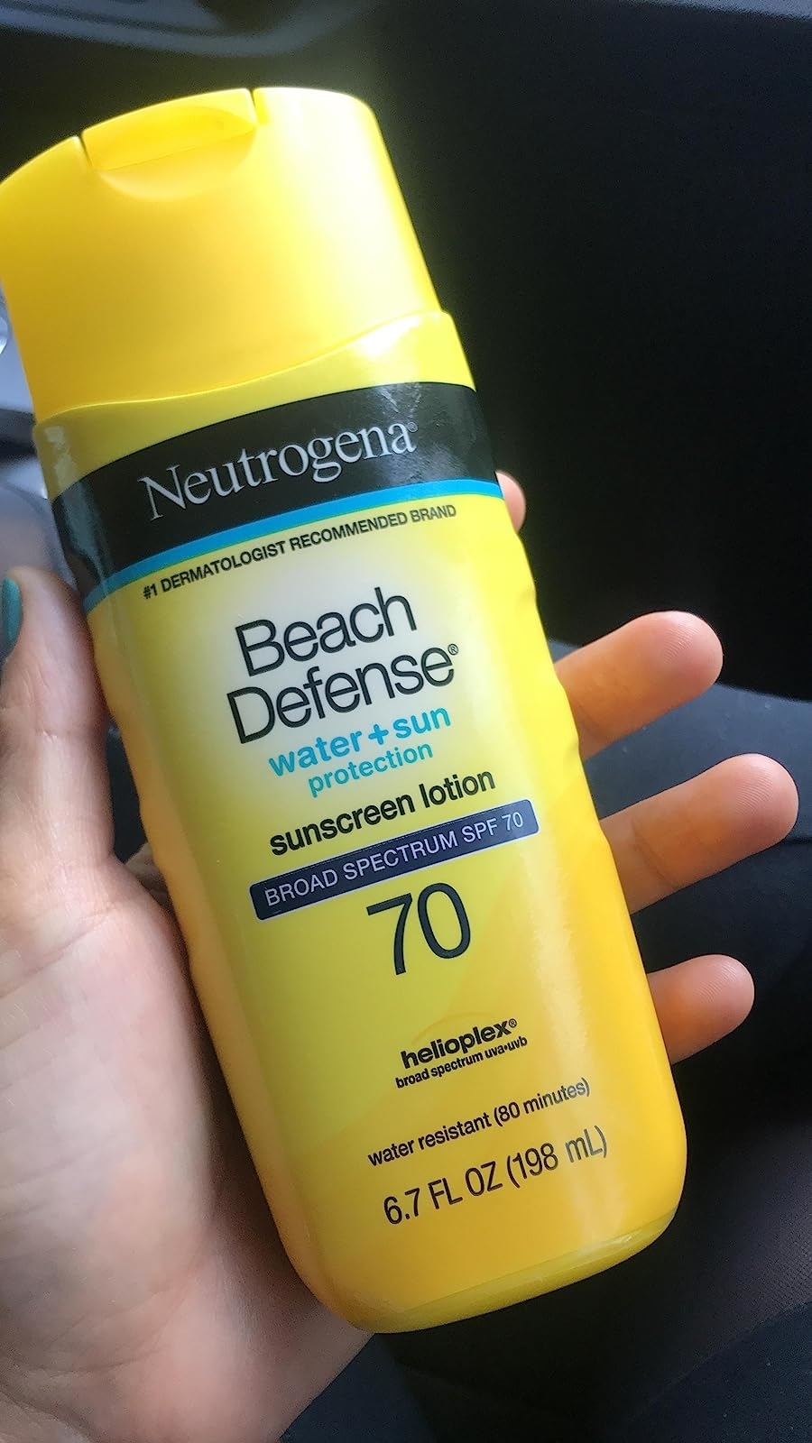 reviewer holding a bottle of sunscreen