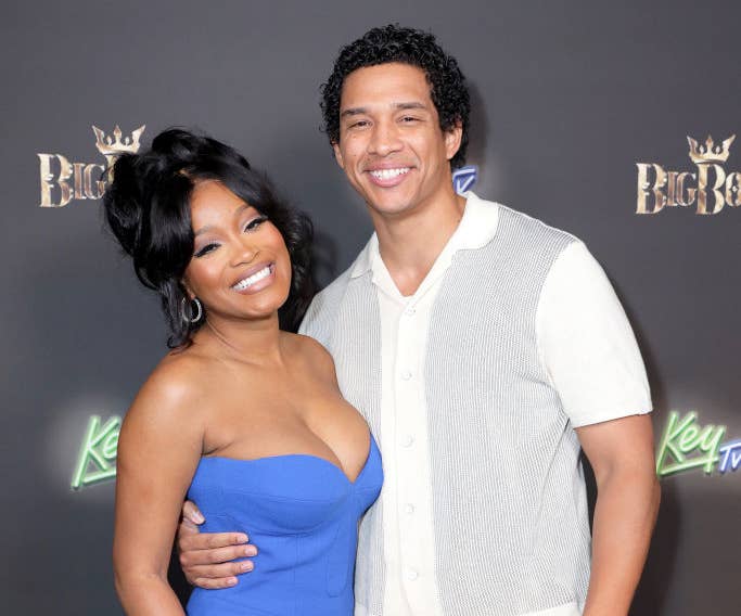 Keke and Darius smile for a photo on the red carpet at a media event