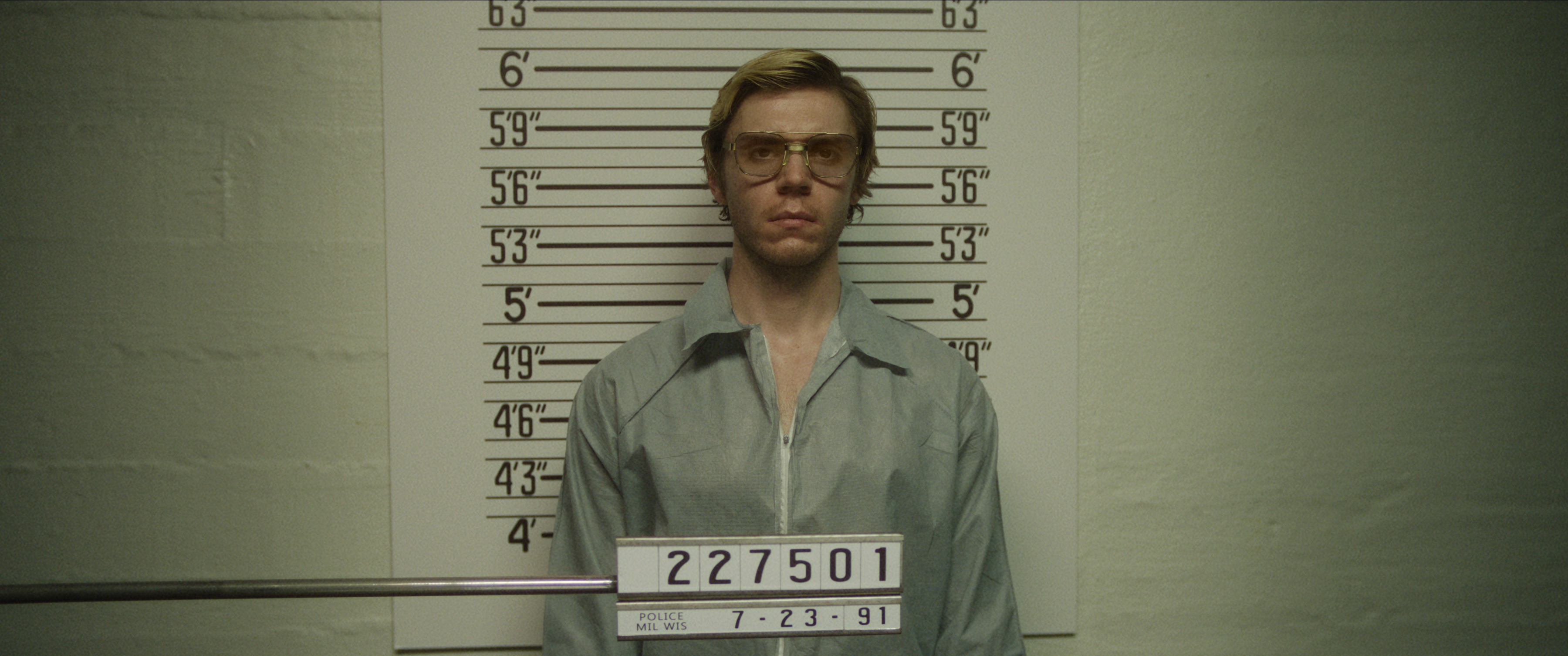Evan Peters as Jeffrey Dahmer getting his mugshot taken in Dahmer — Monster: The Jeffrey Dahmer Story