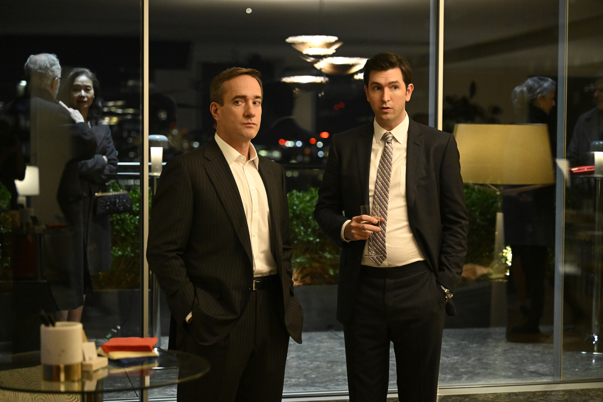 Matthew Macfadyen and Nicholas Braun standing at a party in a scene from Succession