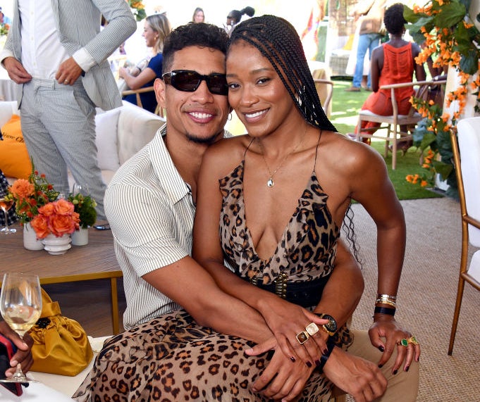 Keke sitting on Darius&#x27;s lap at an event as they smile for a photo