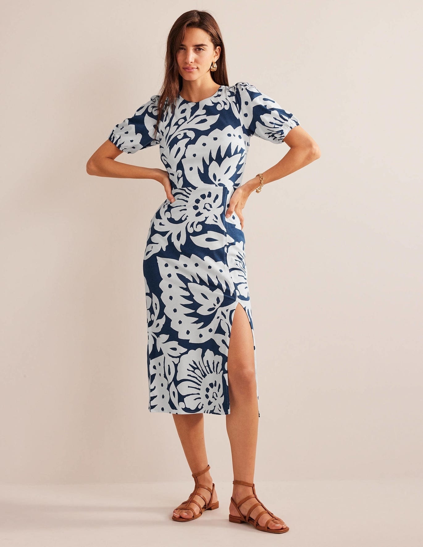 Model wearing printed dress with leg slit.