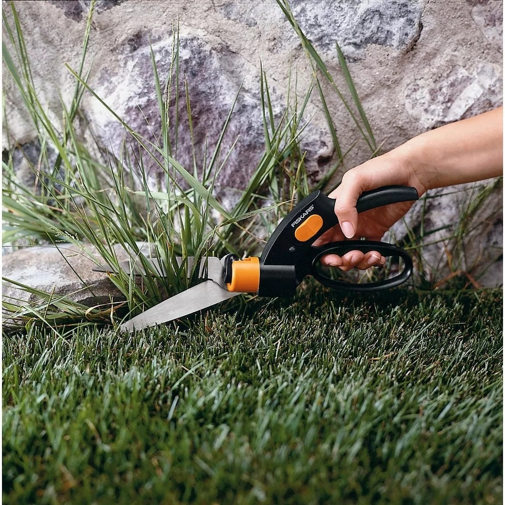 the shears being used to trim grass