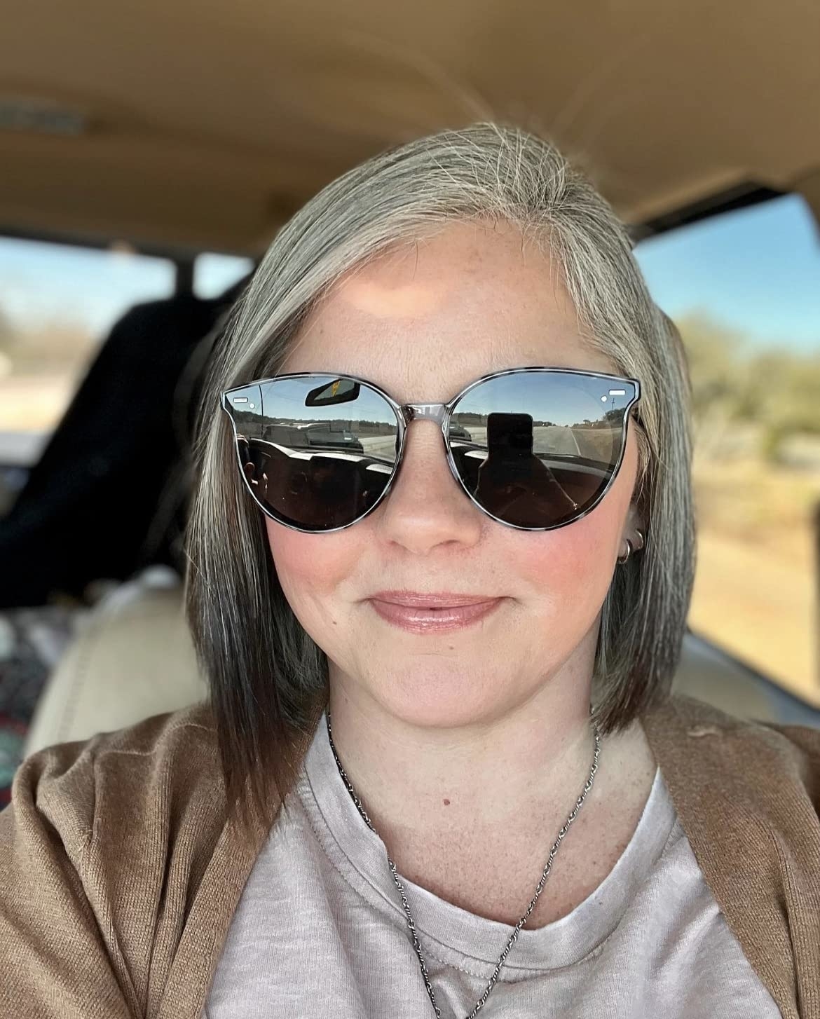 reviewer wearing the large round sunnies