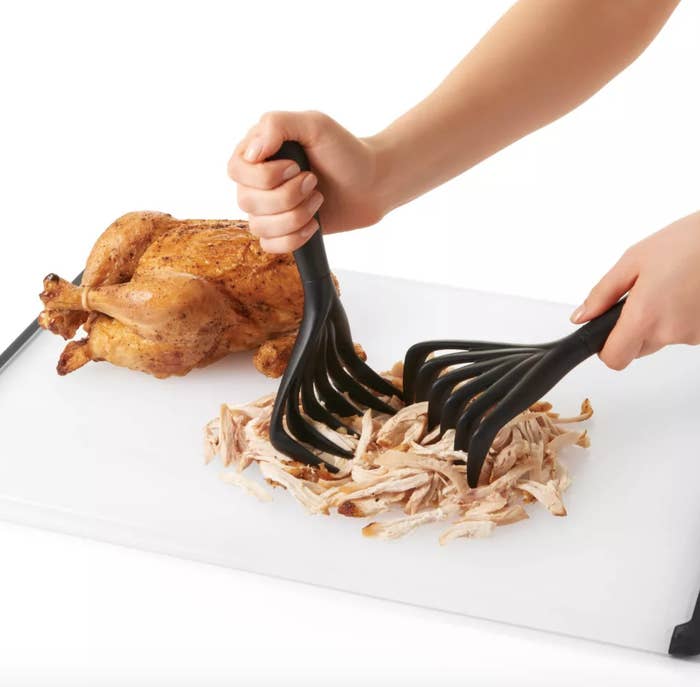 a roasted chicken being shredded by meat shredding claws