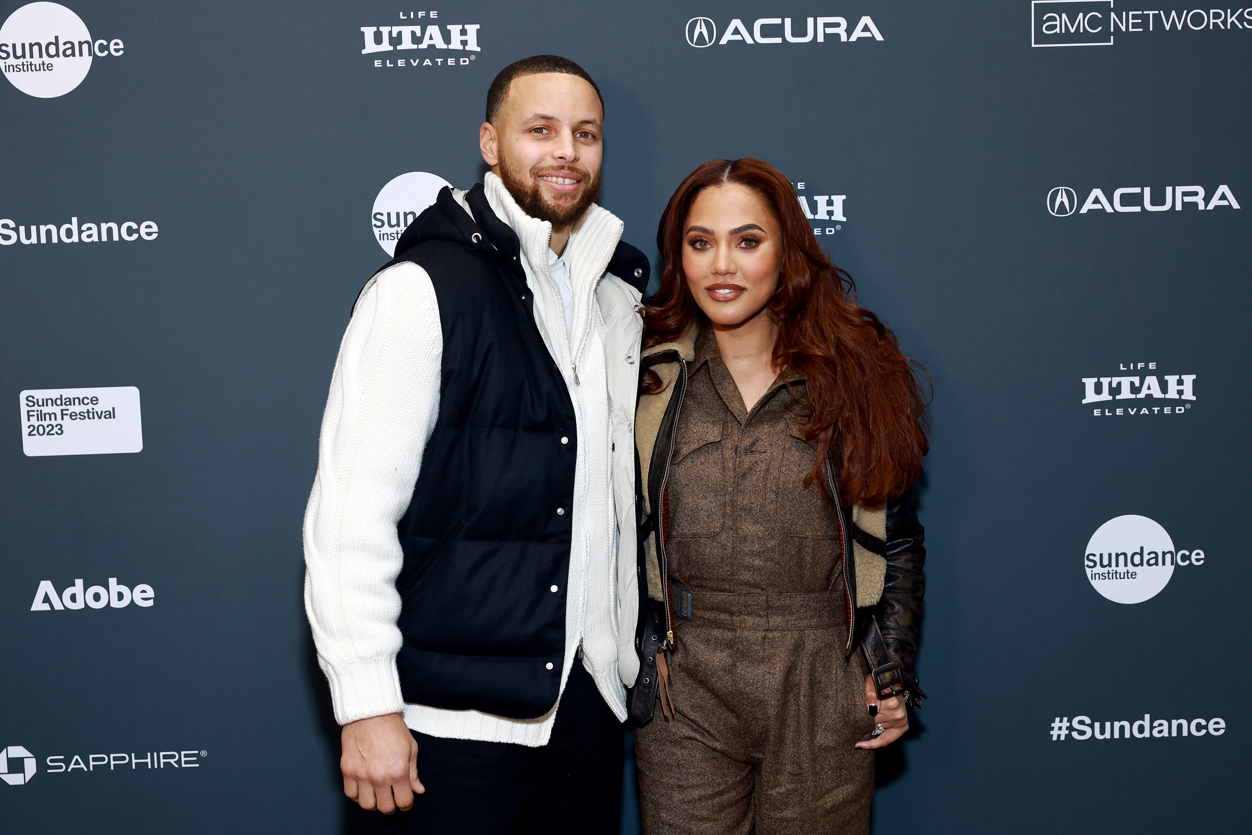 Stephen Curry and his wife Ayesha smile for photographers at a media event