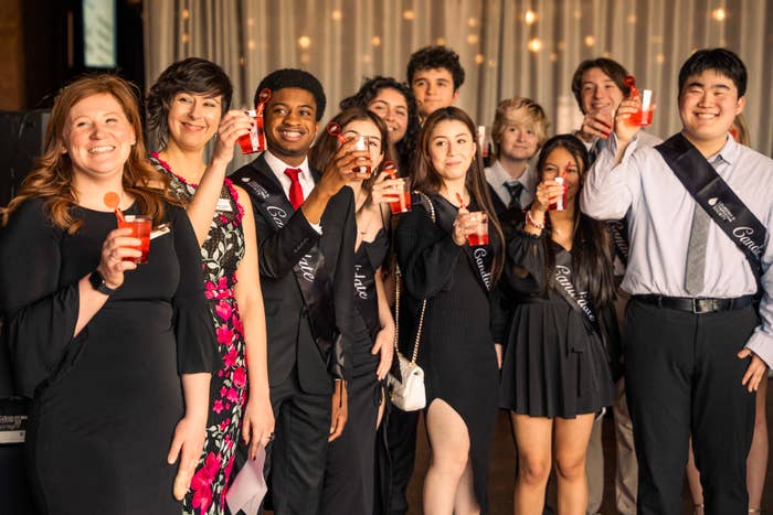 A group of students and adults raising a glass at a formal Student Visionary event.