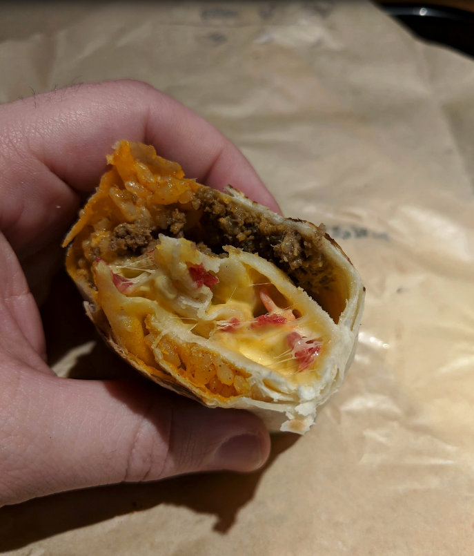 cheesy core burrito in a hand at taco bell