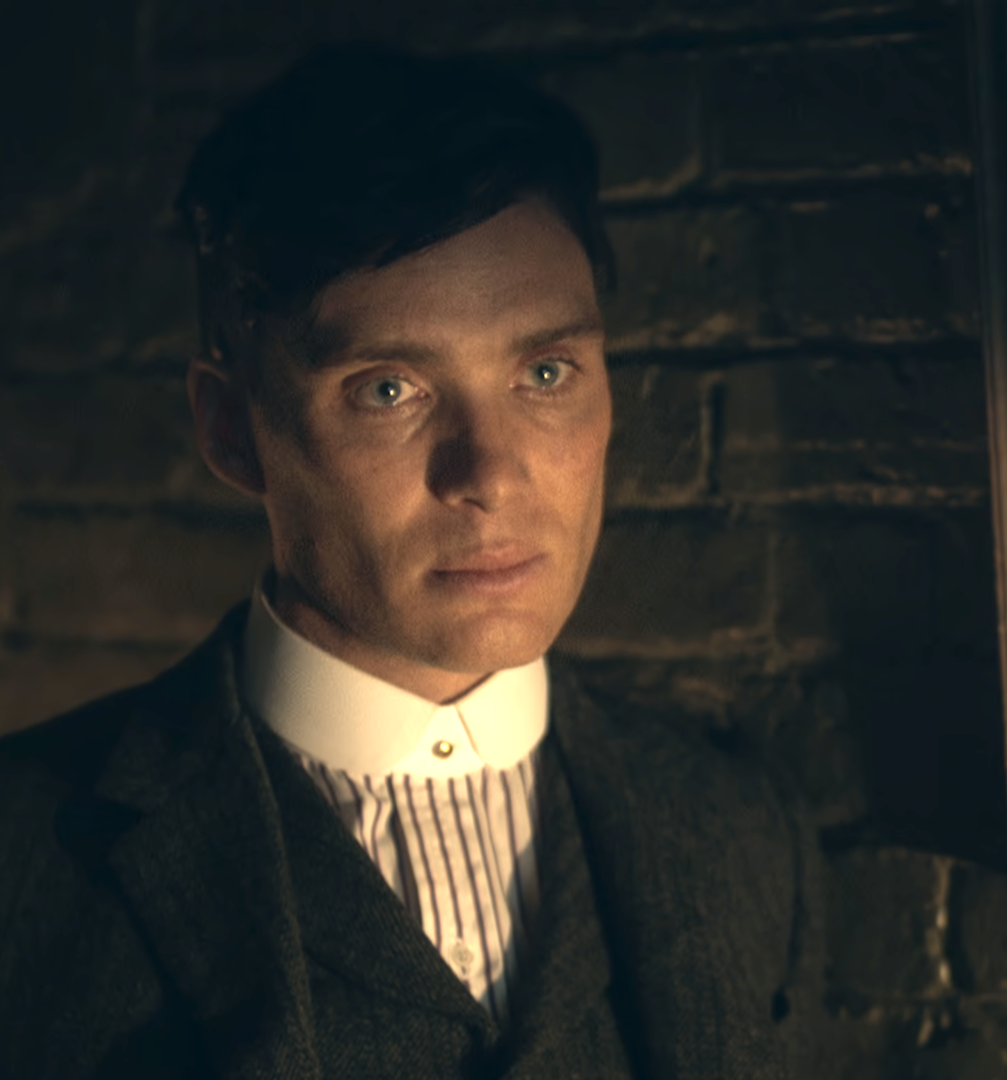 Tommy Shelby staring forward with a somber look