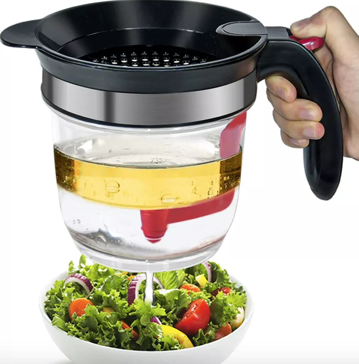 a fat separating device dispensing oil over a salad