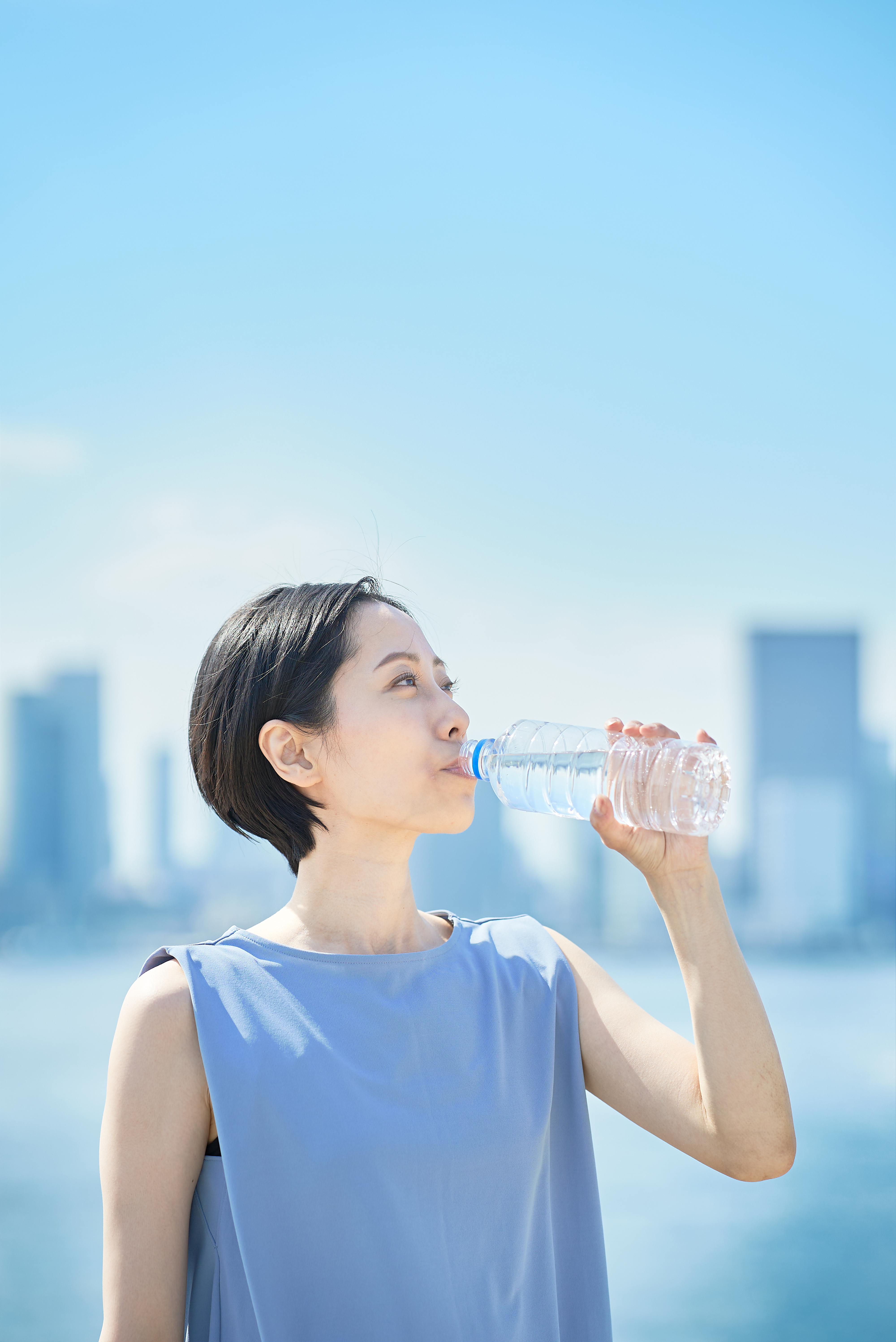 A woman drinking from a bottle of water.