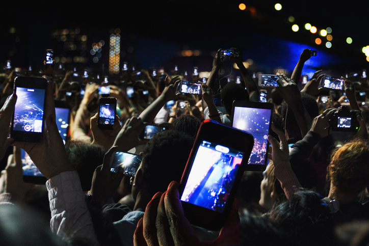 the crowd holding up their phones to record a show