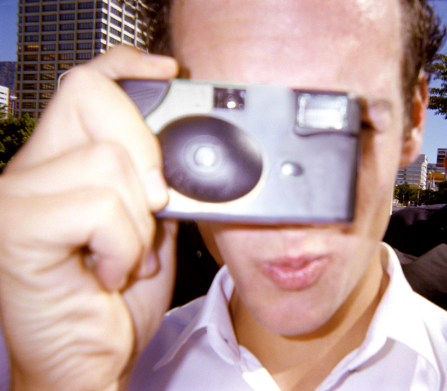 person taking a photo with a disposable camera