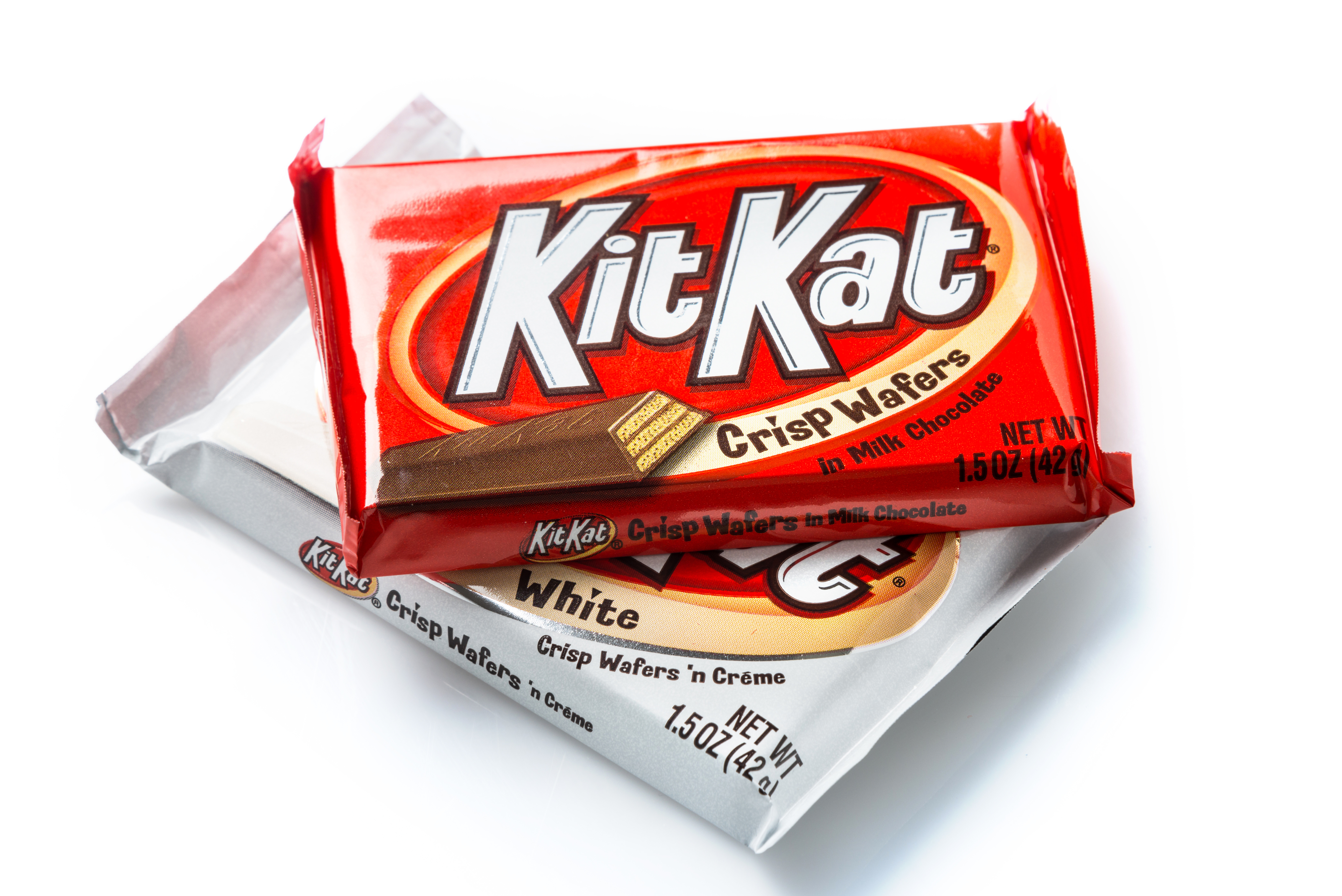 Two Kit Kats in wrappers, one red and one white