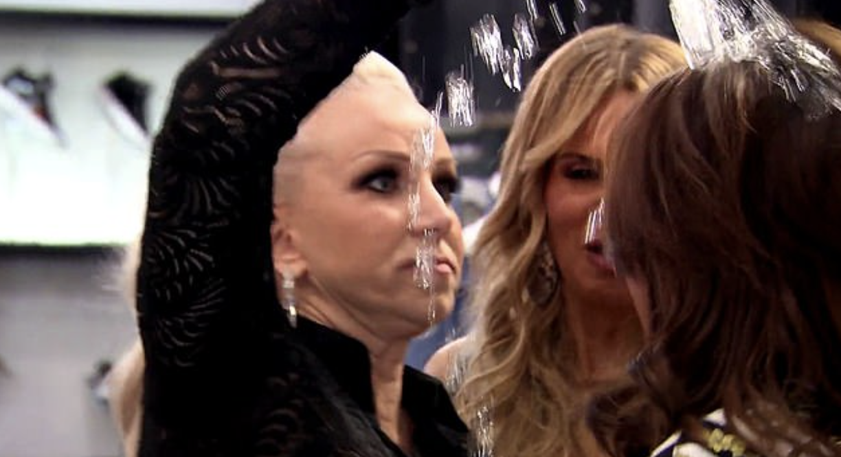 a woman pouring a water bottle on someone else&#x27;s head