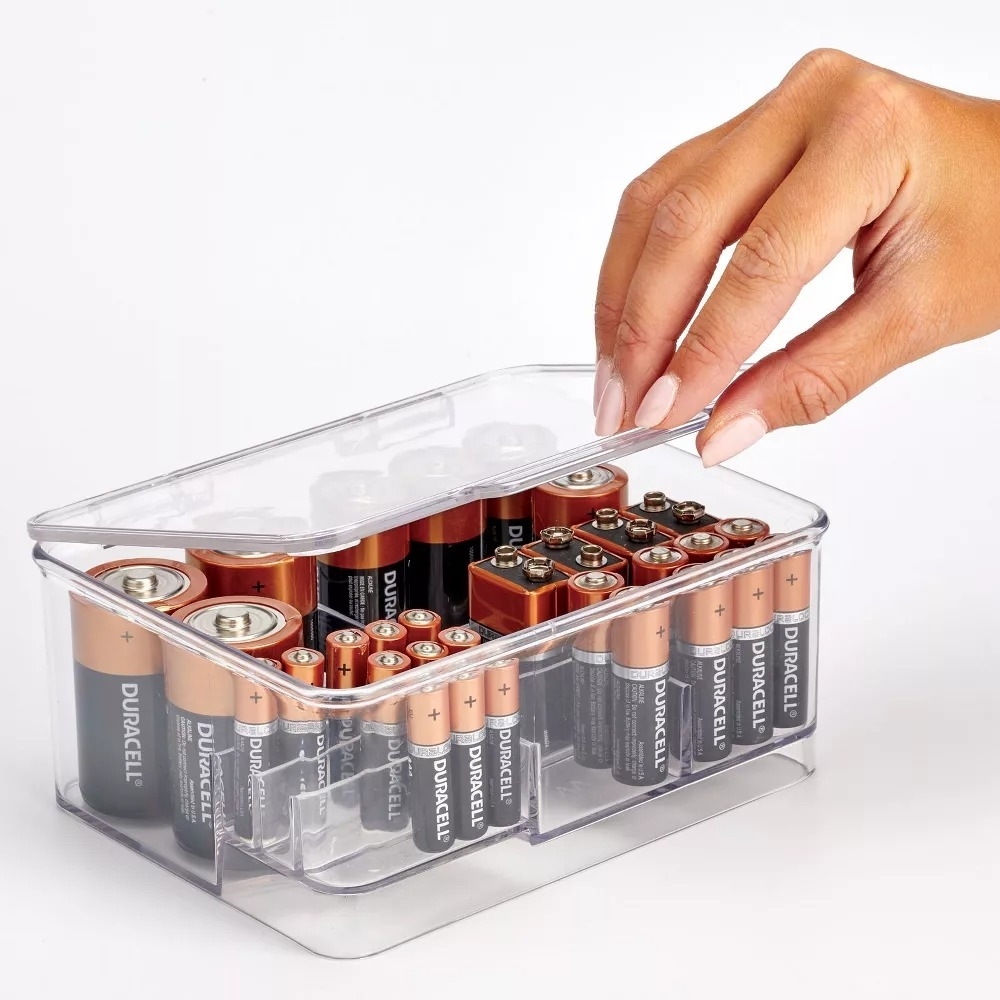 model grabbing battery out of battery storage box