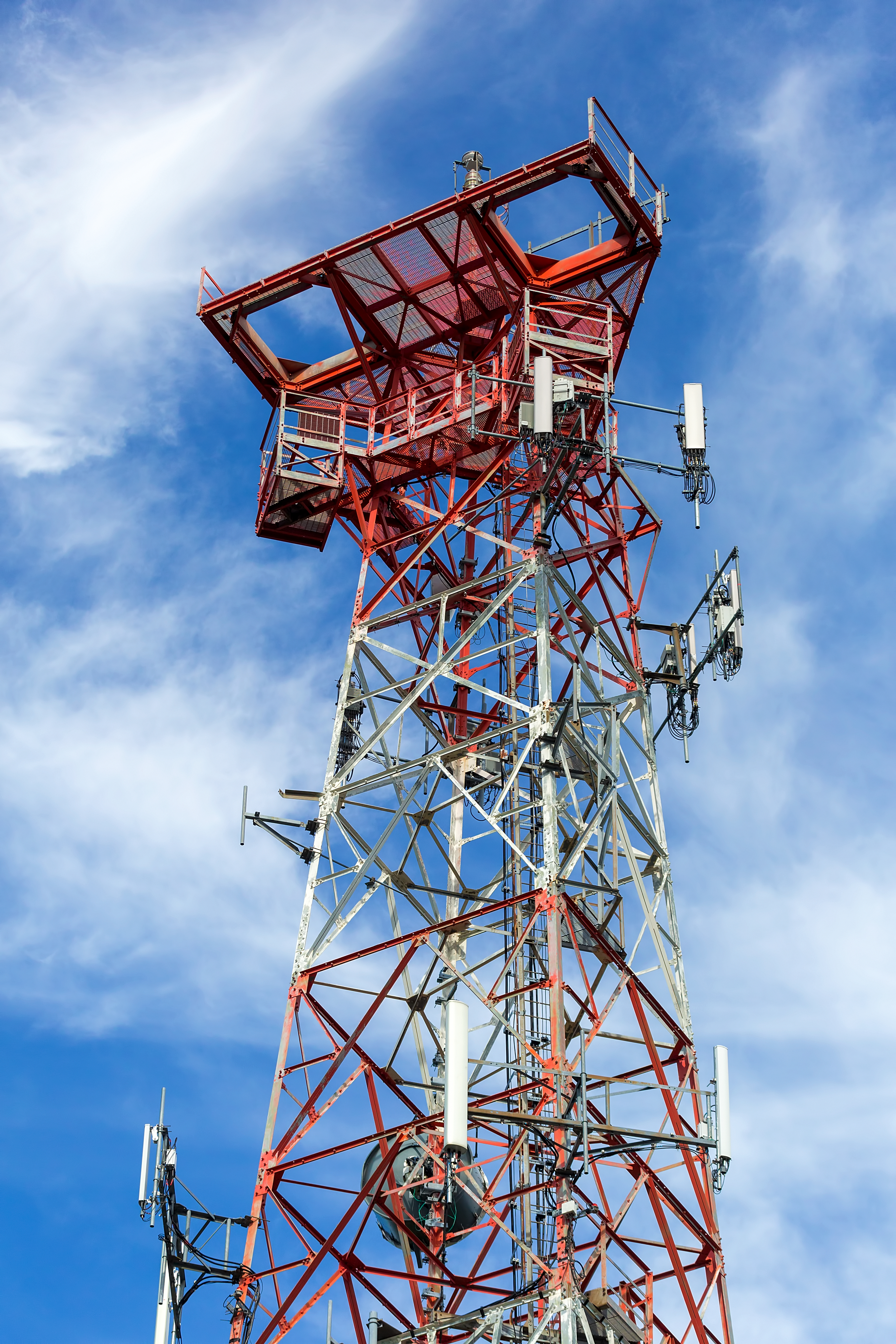 Mobile phone communication internet signal cell tower against blue sky and white clouds