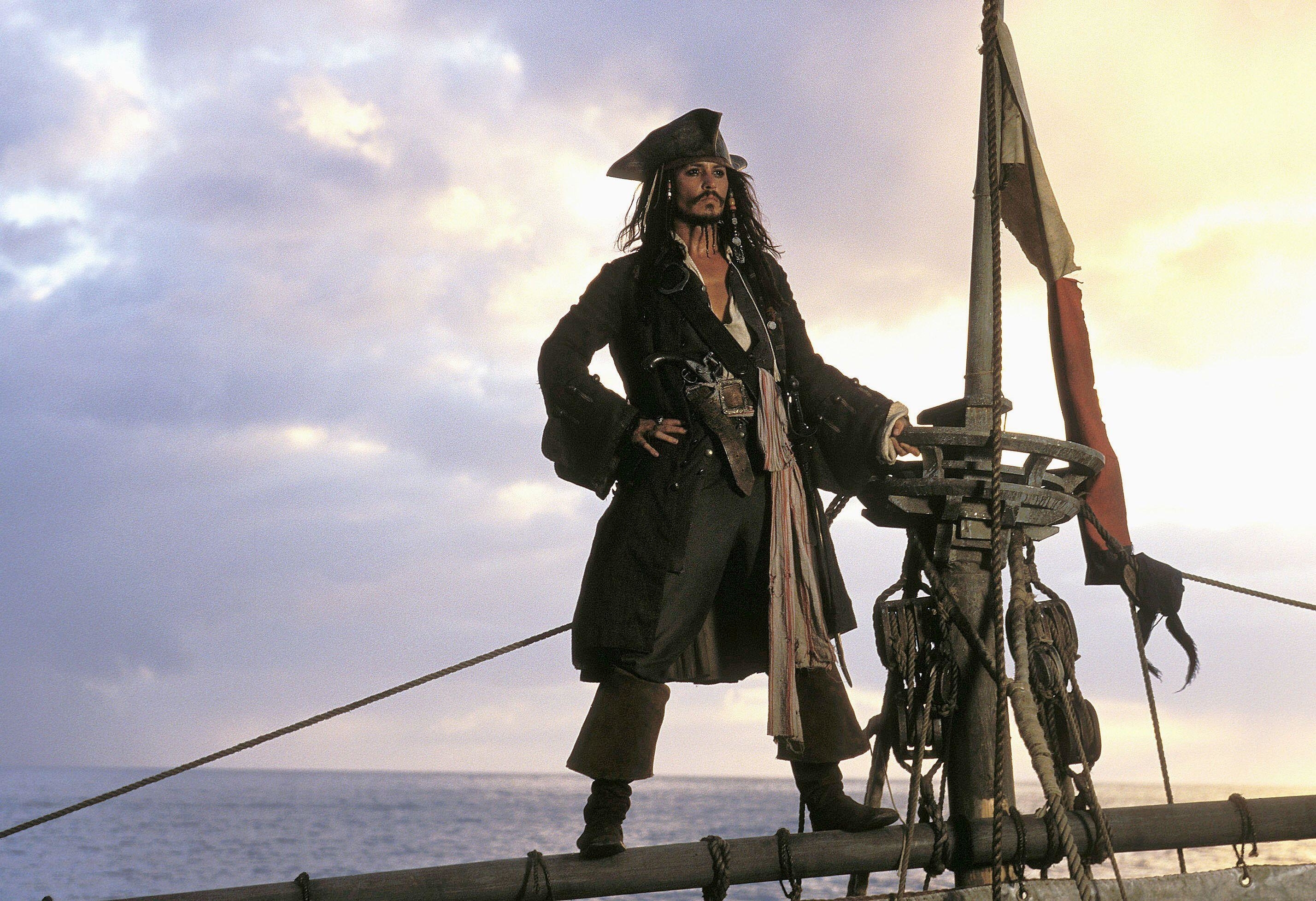 Johnny Depp standing on a ship looking at the ocean in Pirates of the Caribbean: The Curse of the Black