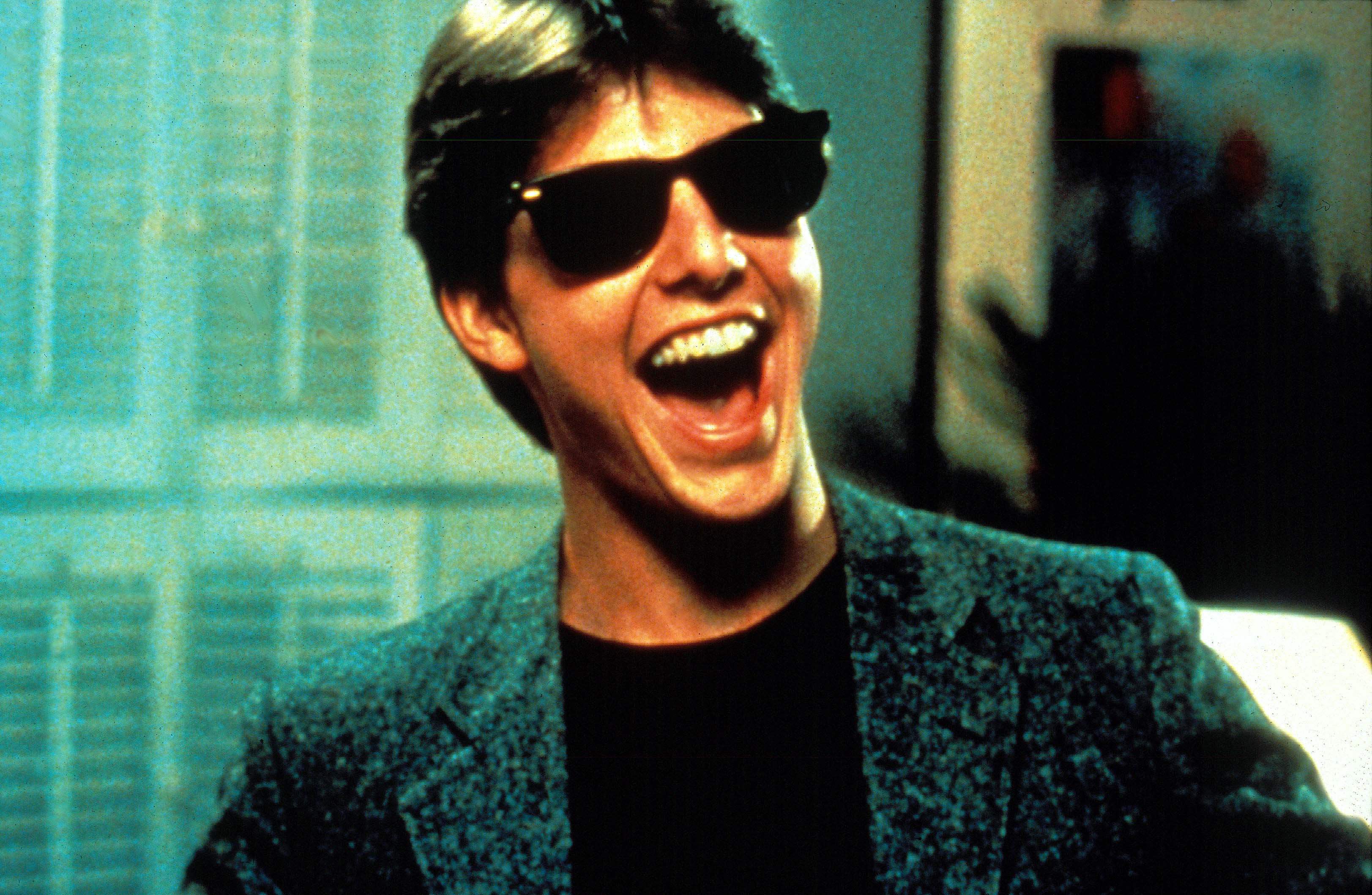Tom Cruise wearing sunglasses and smiling in Risky Business