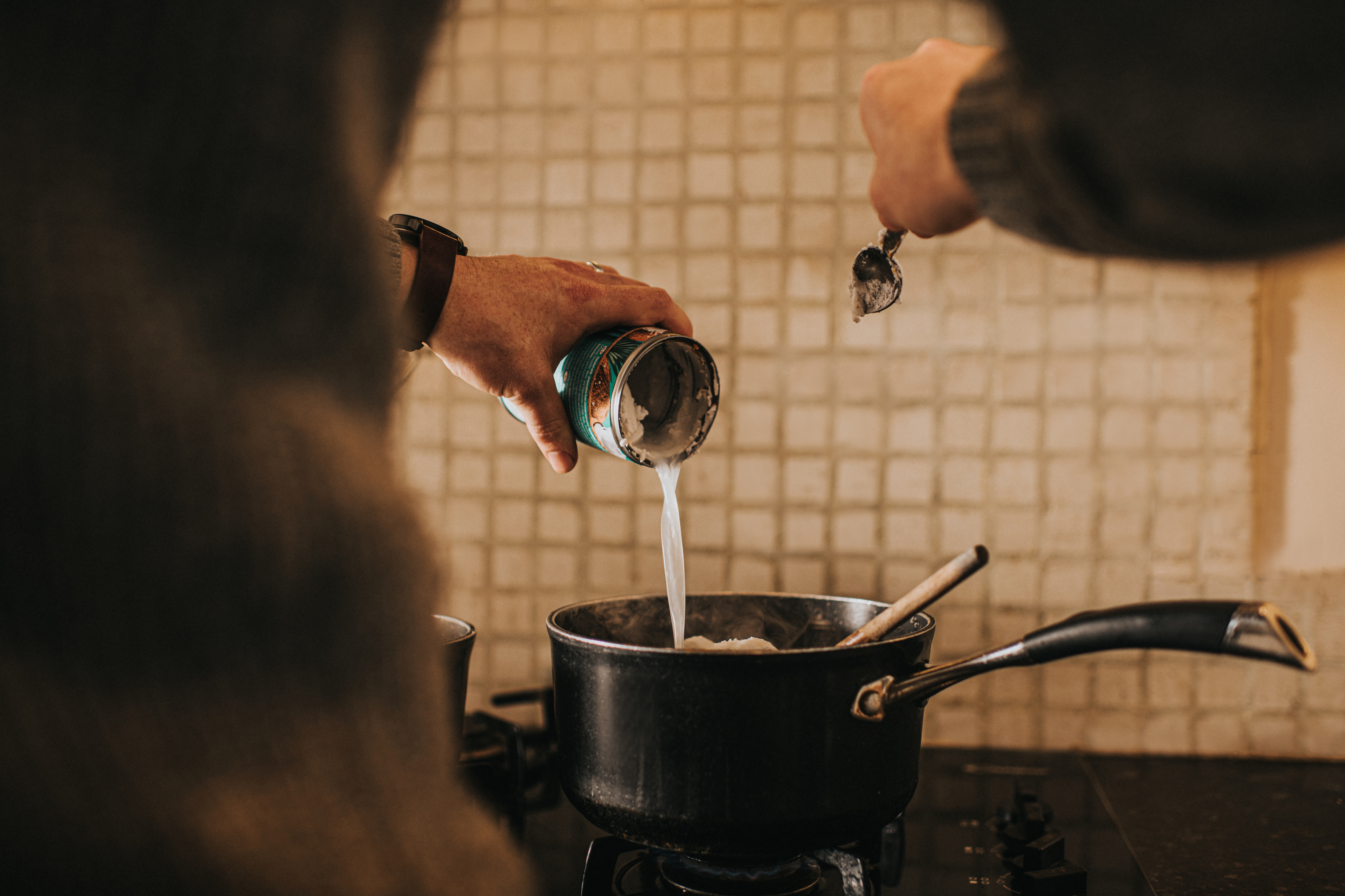 adding coconut milk to a saucepan