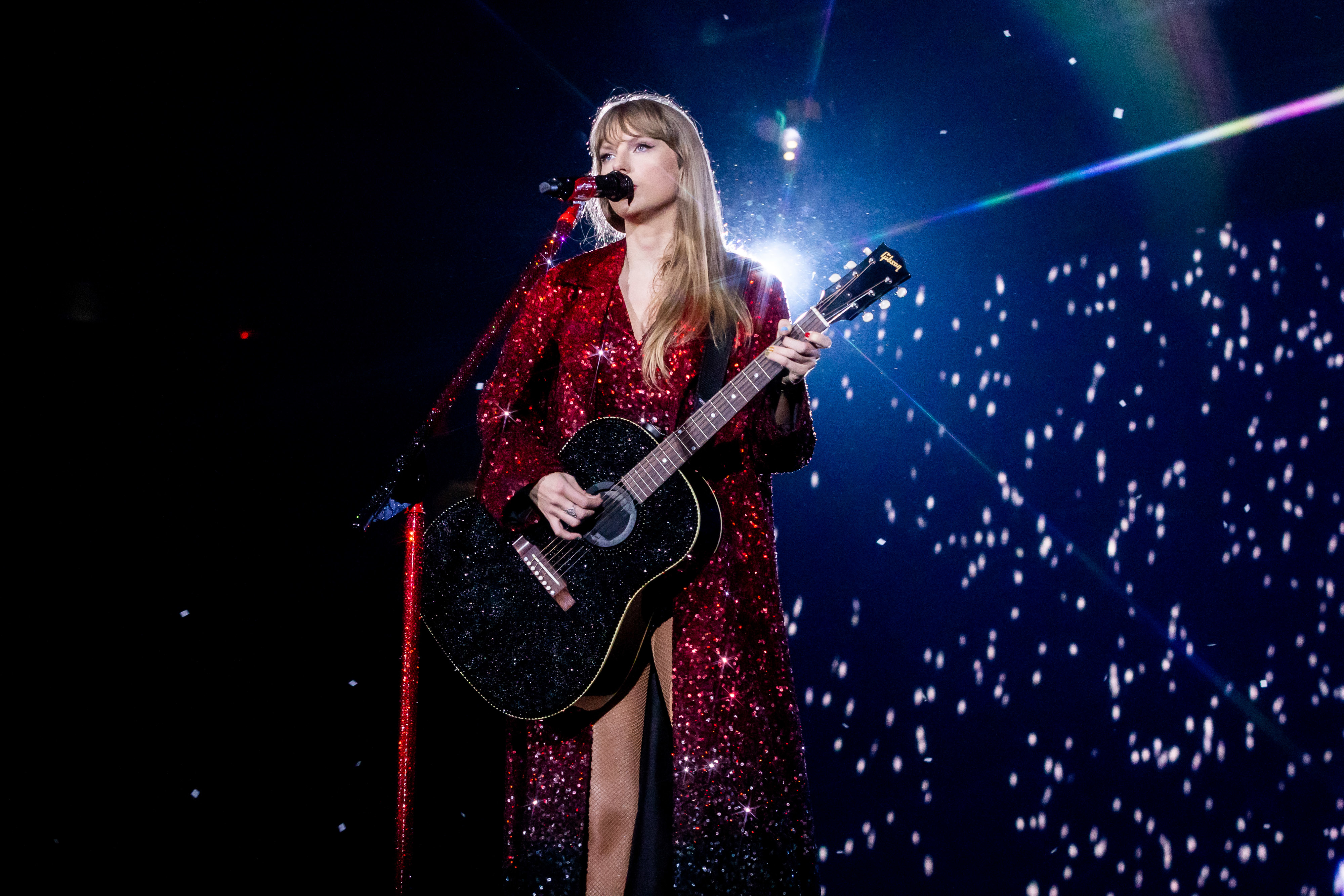 Taylor Swift performing in a sparkling red dress during the &quot;Red&quot; setlist of The Eras Tour