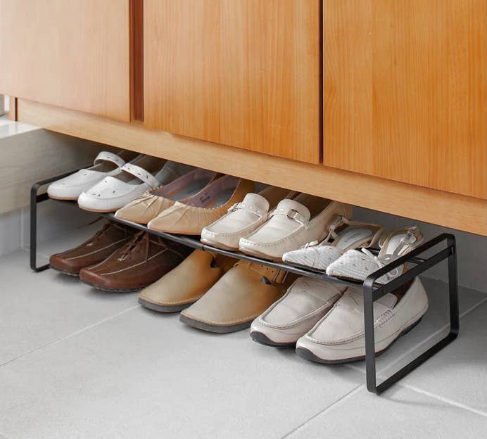 the rack in black with shoes on it
