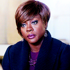 A GIF of Viola Davis looking skeptical and annoyed, reaching for her handbag to stand up and walk away