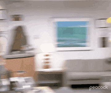 A GIF of Dwight from the Office walking and wearing a yellow Hazmat suit