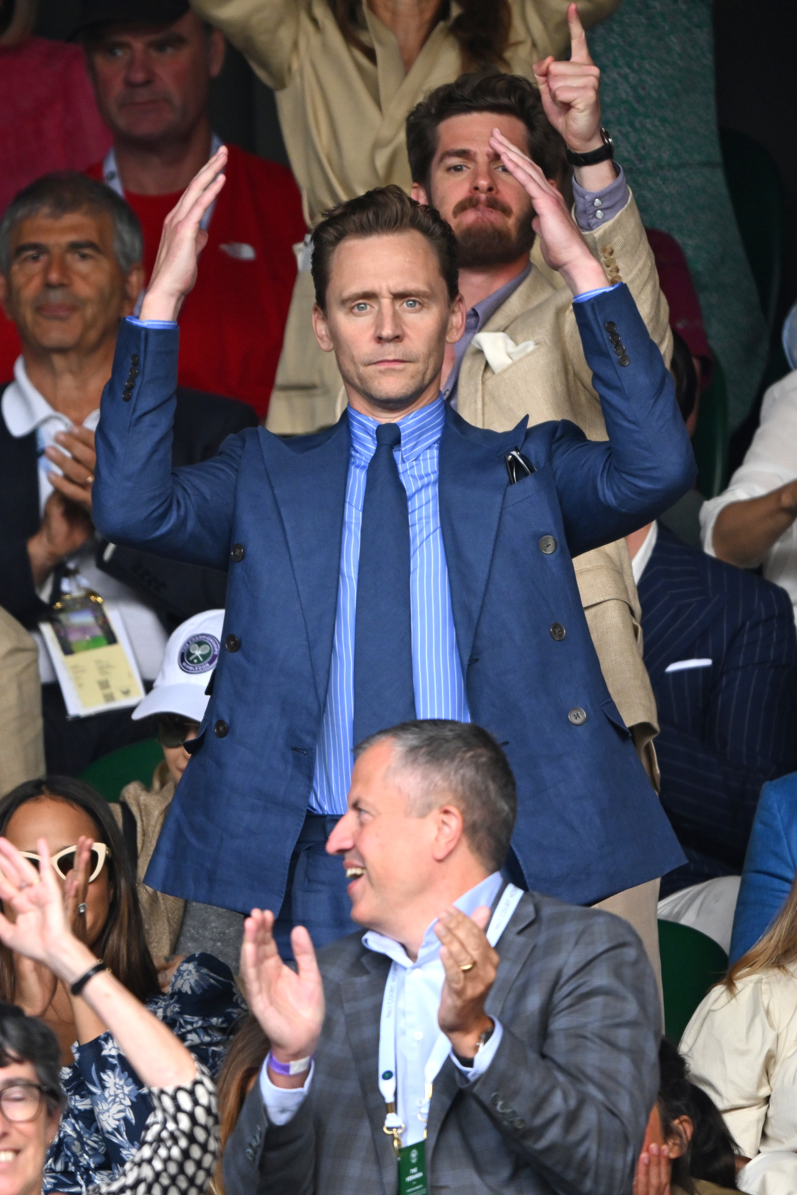 Tom standing with his arms raised