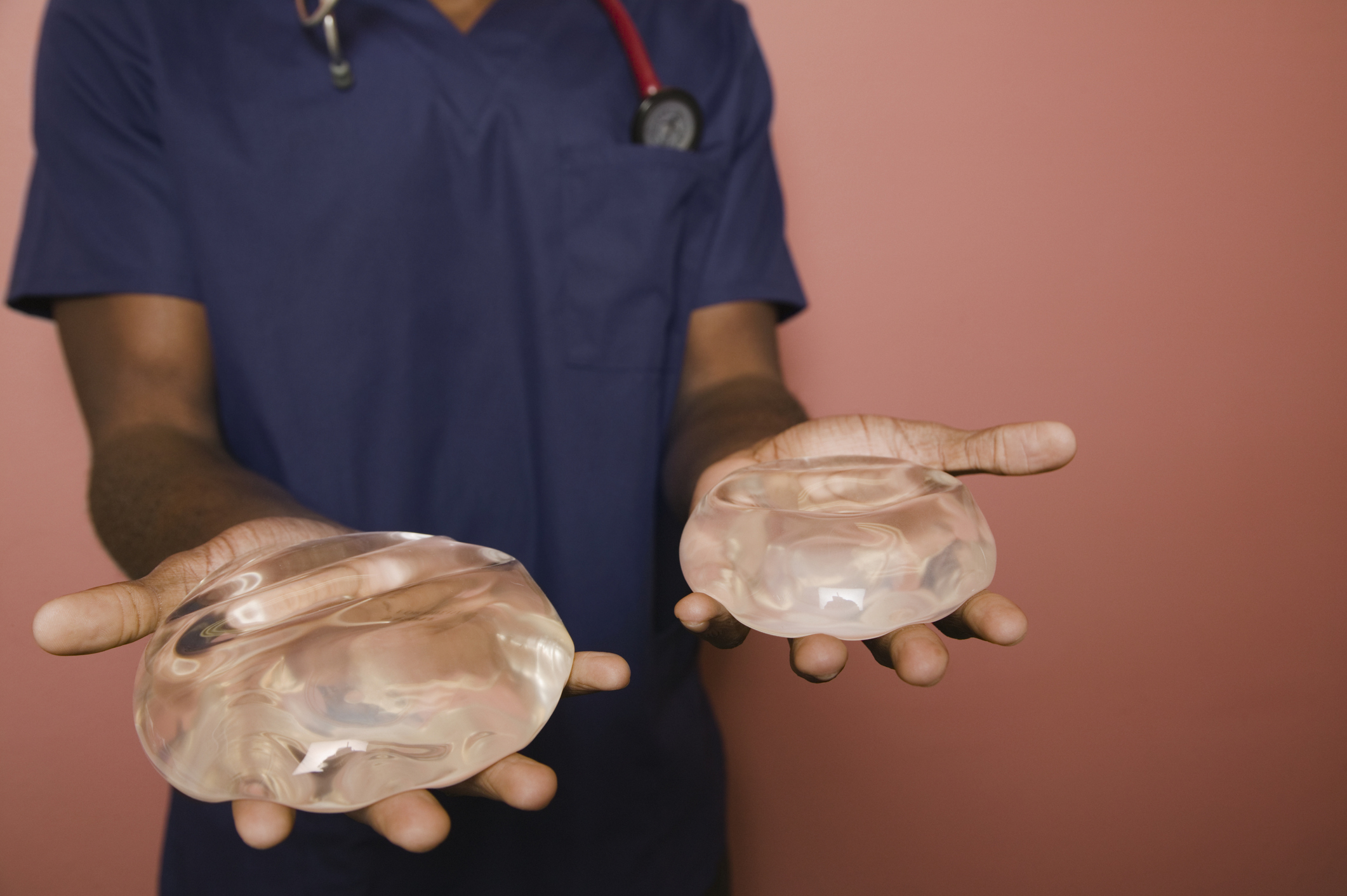 Medical professional holding up breast implants