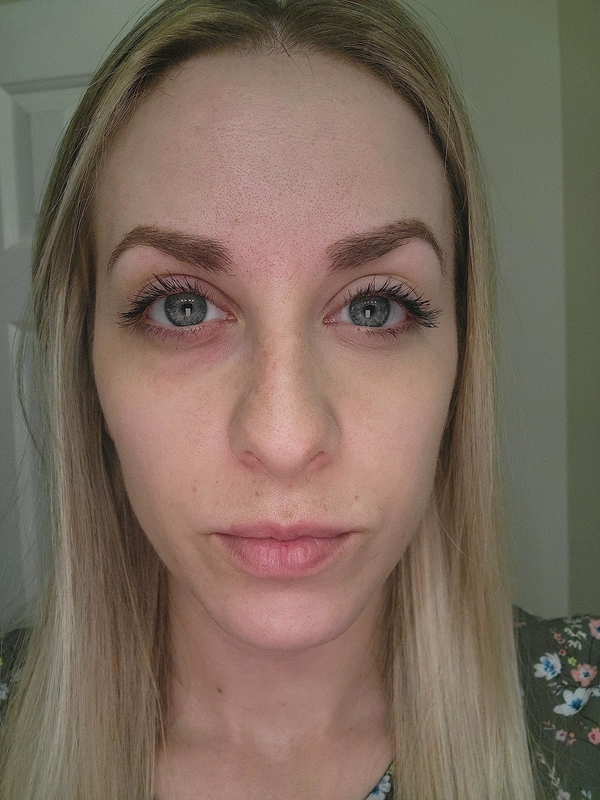 A reviewer showing one side of their face without the foundation and the other side before.