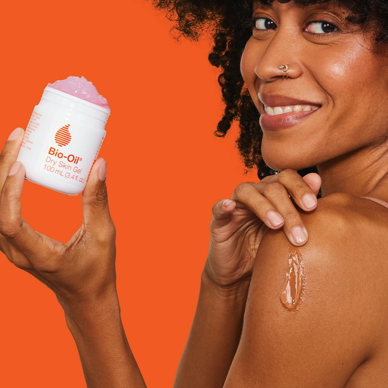 A model using the product on her skin with a orange background