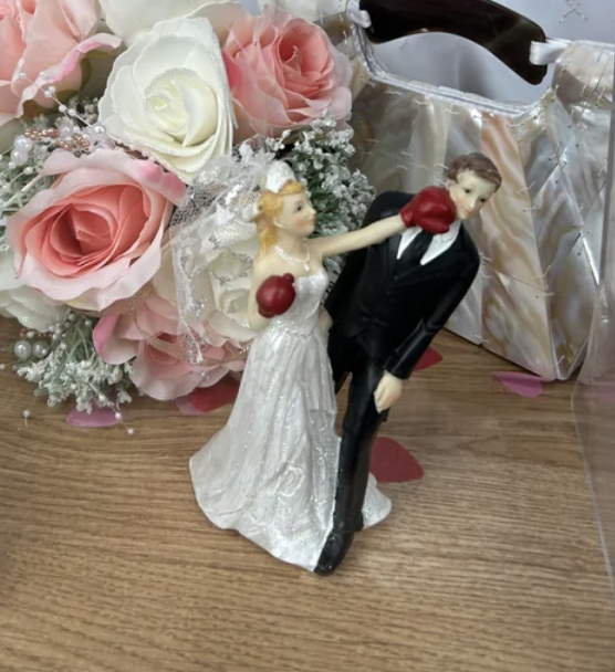 Cake toppers where the bride is punching the groom