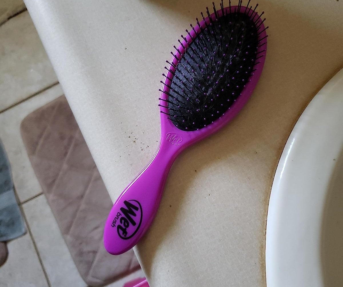 a reviewer photo of the purple hair brush