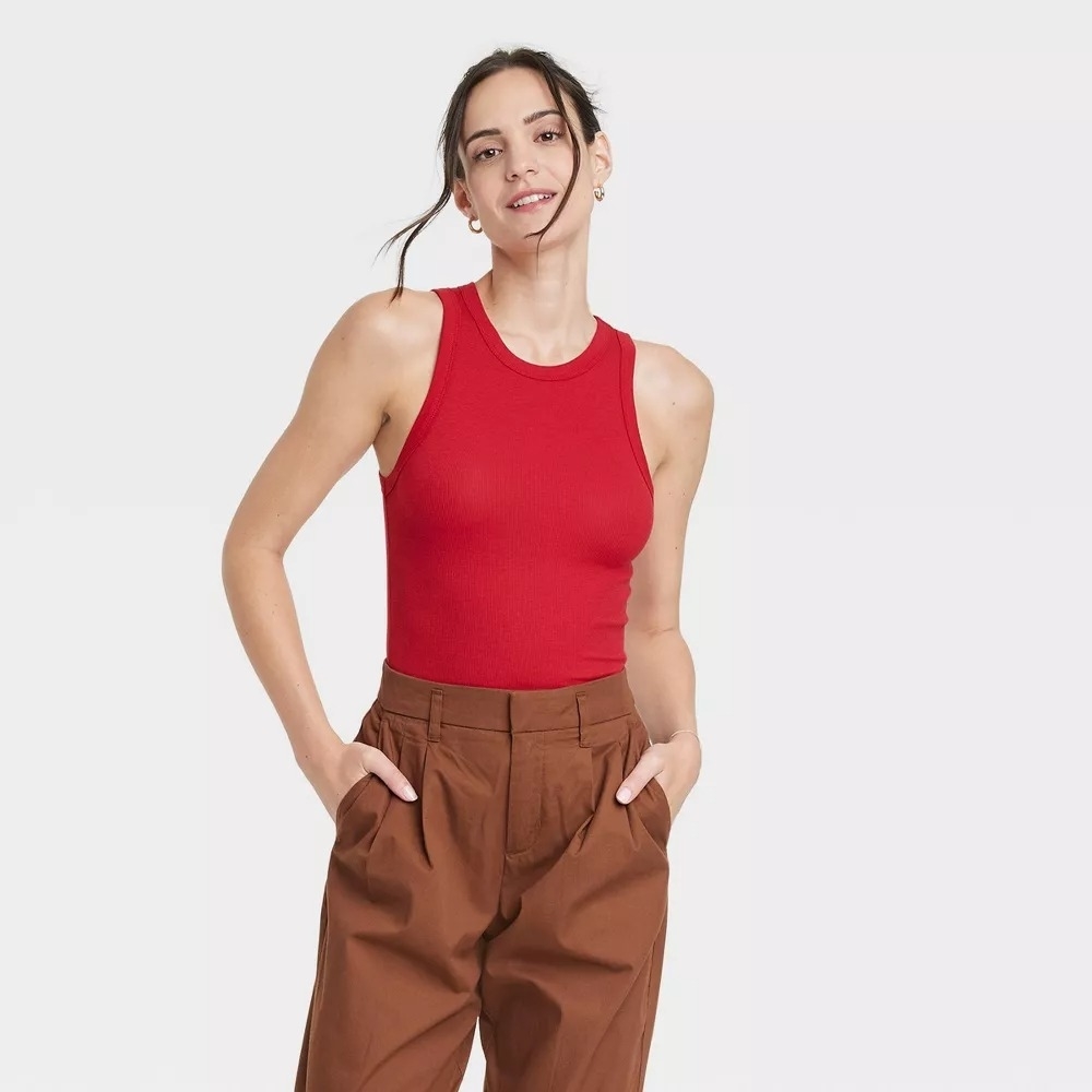 model wearing high-neck red ribbed tank top with brown pants