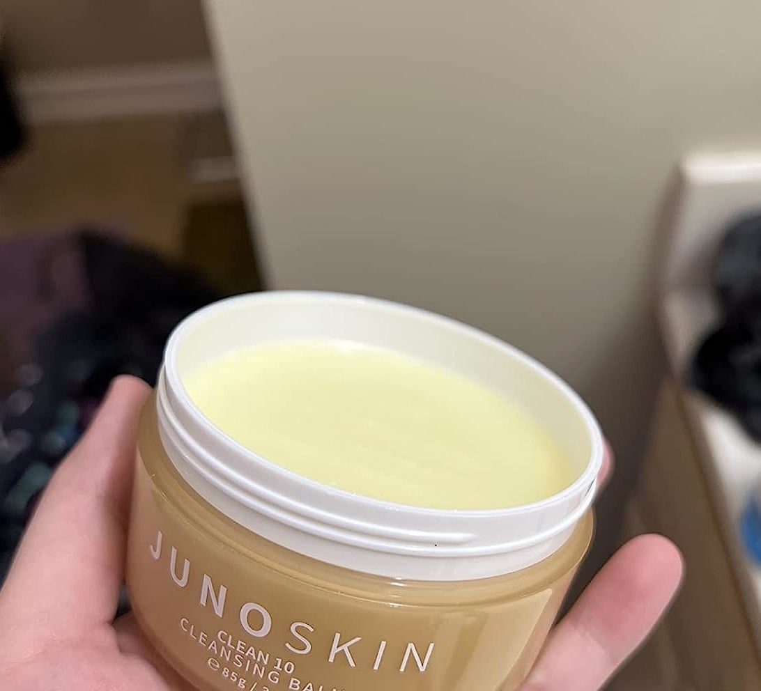 Reviewer holding an open container of the cleansing balm