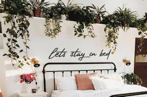script lettering over a bed that says "let's stay in bed"